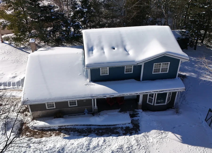 Aerial drone view of winter home inspection showing snow-covered roof in Quispamsis New Brunswick