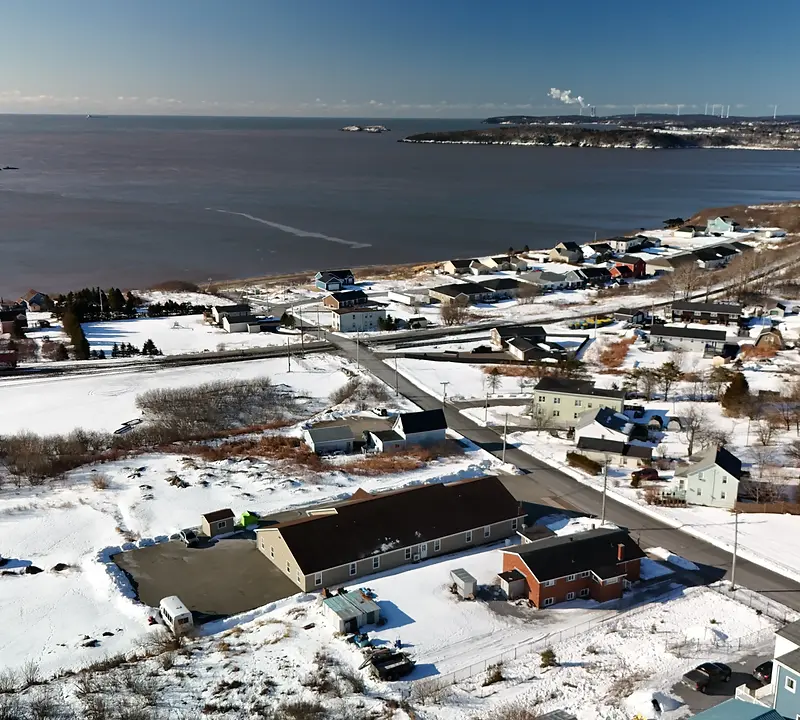 Residential street in Saint John New Brunswick showing early spring conditions with snow melting and for sale signs visible